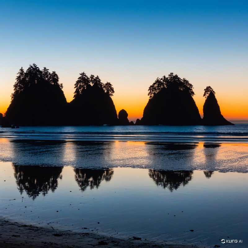 奥林匹克国家公园宁静海滩上令人惊叹的日落，岩石海垛的剪影，从深蓝过渡到暖橙色的生机勃勃的天空，平静倒影的海水，宁静祥和的氛围