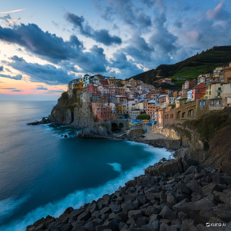 夕阳下的海滨村庄景色迷人，悬崖边的房屋色彩斑斓，可以俯瞰大海，海浪轻轻拍打着岩石，天空中的云朵波澜壮阔，景色宁静如画，令人陶醉，气氛祥和