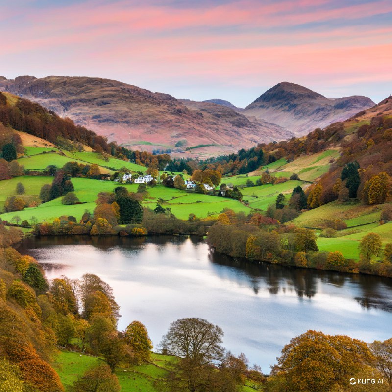 秋季的英格兰湖区格拉斯米尔风景宁静如画，平静的湖面倒映着秋叶的缤纷色彩，翠绿的草地和连绵起伏的山丘在粉色的天空下交相辉映